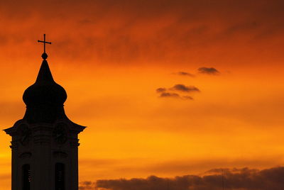 Silhouette church against orange sky