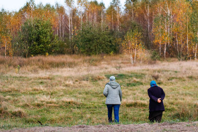 Rear view of man walking on field