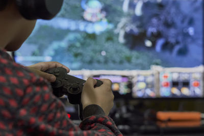 Midsection of boy playing video games