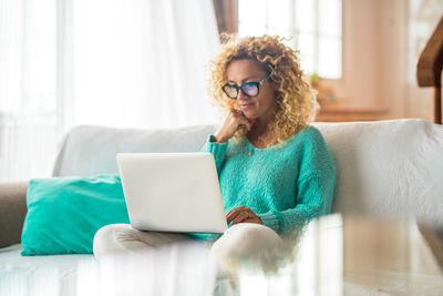 Young woman using mobile phone at home