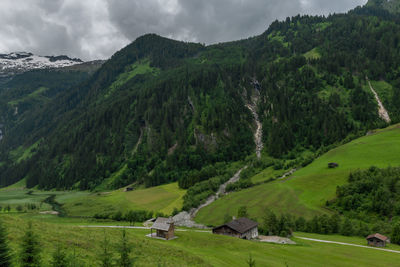 Scenic view of green landscape and mountains against sky