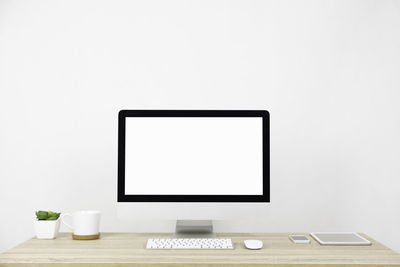 Coffee cup on table against white wall