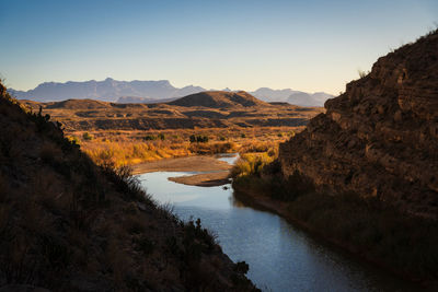 Scenic view of lake and mountains against clear sky