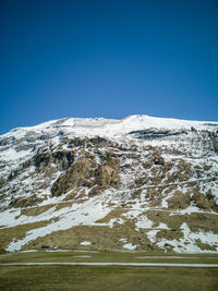 Scenic view of snowcapped mountains against clear blue sky