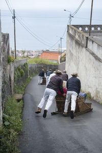 Rear view of people sitting on road