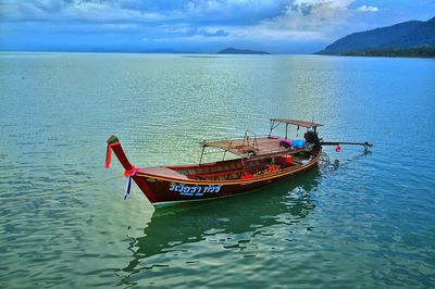 People on boat in sea against sky