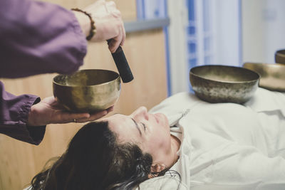 Woman practicing holistic activities with tibetan bells meditation exercises for calm and clear mind