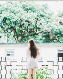 Rear view of woman standing against building