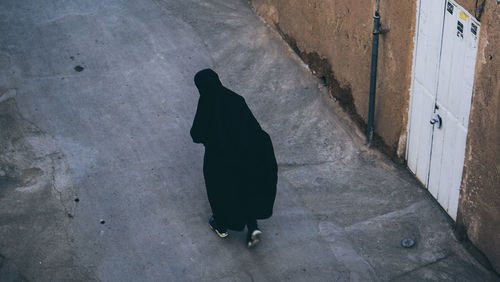 High angle view of black cat walking on street