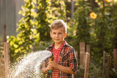 Portrait of smiling boy holding plant