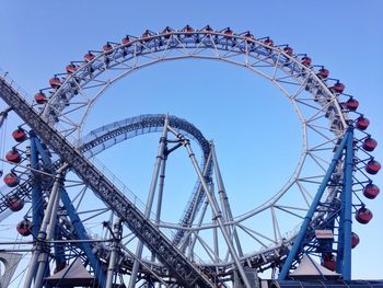 Low angle view of ferris wheel against blue sky