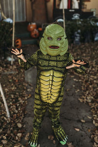 Young boy dressed as sea monster posing in costume at halloween