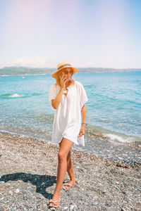 Full length of young woman standing on beach