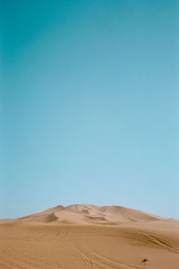 Scenic view of desert against clear blue sky