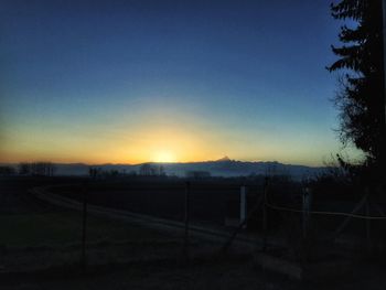 Fence against sky during sunset