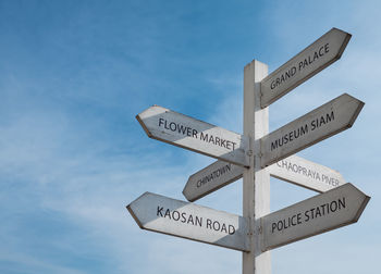 Low angle view of road sign against blue sky