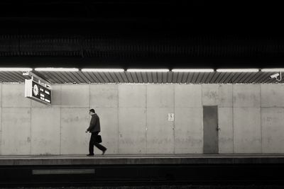 Side view of a man walking on railway station platform