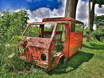 Abandoned truck on field against sky
