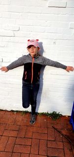 Portrait of cute boy standing against wall