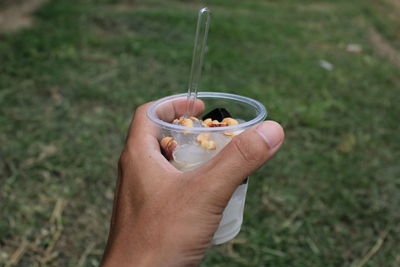 Midsection of person holding ice cream in bowl