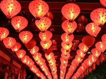 Low angle view of illuminated lanterns hanging against sky