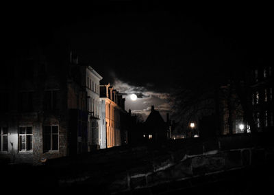 Illuminated houses against sky at night