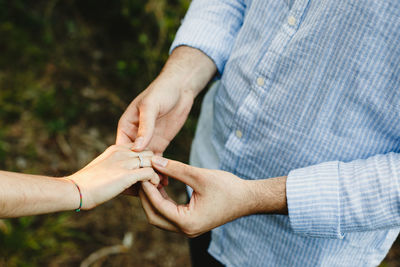 Midsection of couple holding hands