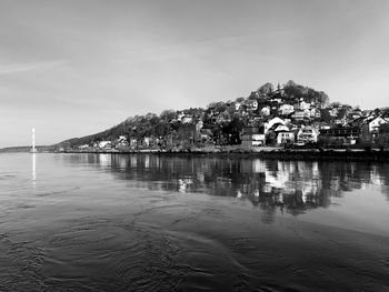 Scenic view of sea by townscape against sky