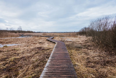 Wooden path leading through moorland in winter