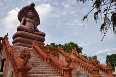 Low angle view of statue against temple against sky