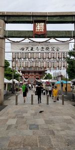People on street amidst buildings in city