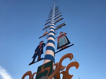 Low angle view of sign against clear blue sky