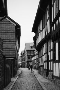 People walking on street amidst buildings against sky