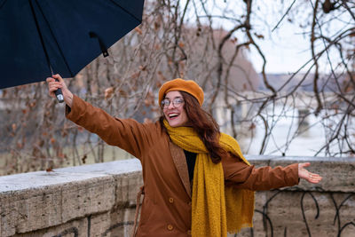 Young woman standing by tree during winter