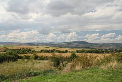 Scenic view of field against cloudy sky