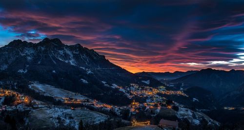 Aerial view of snowcapped mountains against sky during sunset