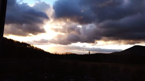 Scenic view of dramatic sky over silhouette landscape