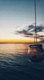 Close-up of water in sea against sunset sky