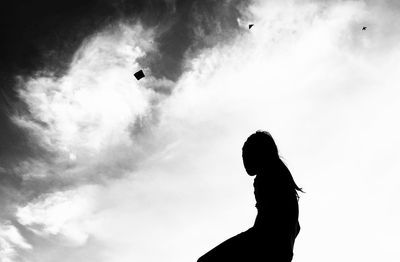 Low angle view of silhouette woman standing against sky