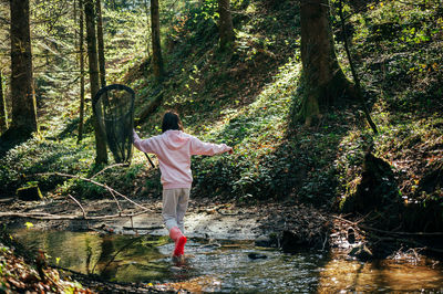 One girl playing in the forest. asian child fishing with a net to discover nature. 