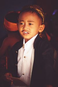Close-up of cute boy in costume looking away standing indoors
