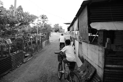 Rear view of people sitting in city against sky