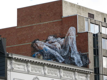 Low angle view of statue against building in city