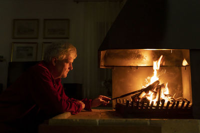 Midsection of man with fire burning at night