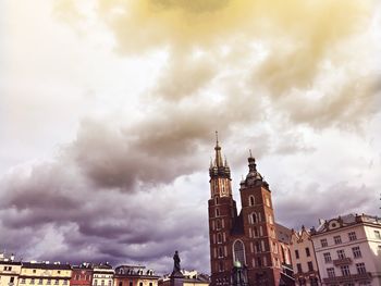 Low angle view of buildings against cloudy sky