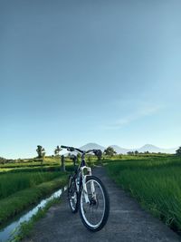 Bicycle on road against clear sky