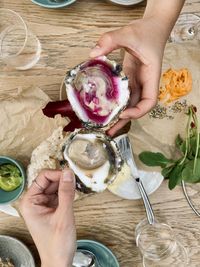 Cropped hands of person holding food on table