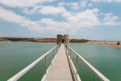 Pier on footbridge against sky