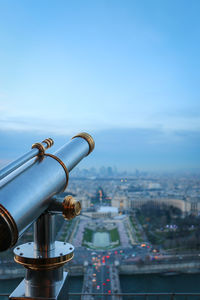 Coin-operated binoculars at eiffel tower against sky in city