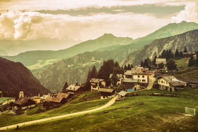 Scenic view of townscape by mountains against sky